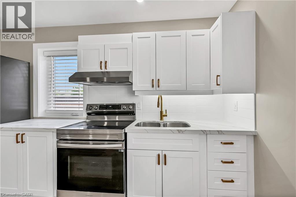 A modern kitchen with white cabinets and stainless steel appliances.