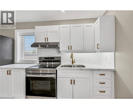A modern kitchen with white cabinets and stainless steel appliances.
