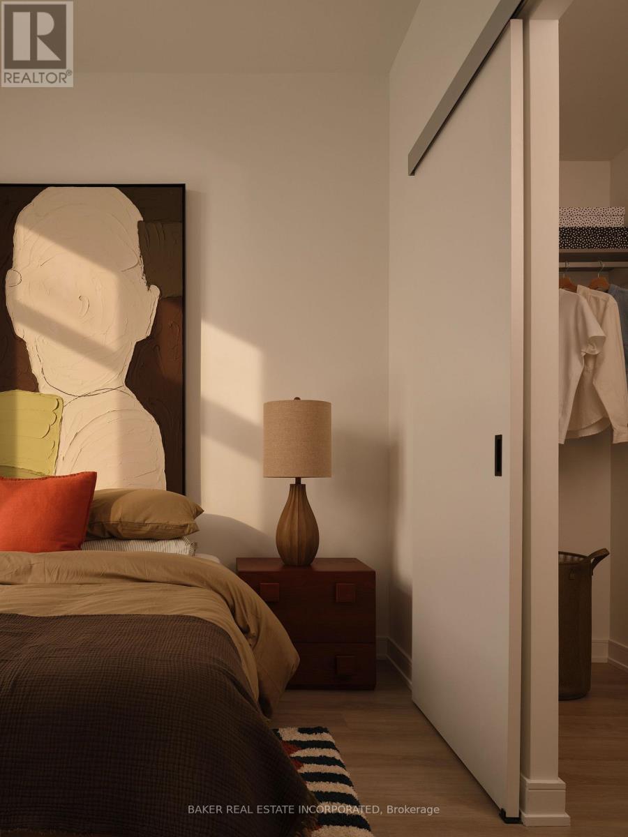 A bedroom with a bed, nightstand, and lamp.