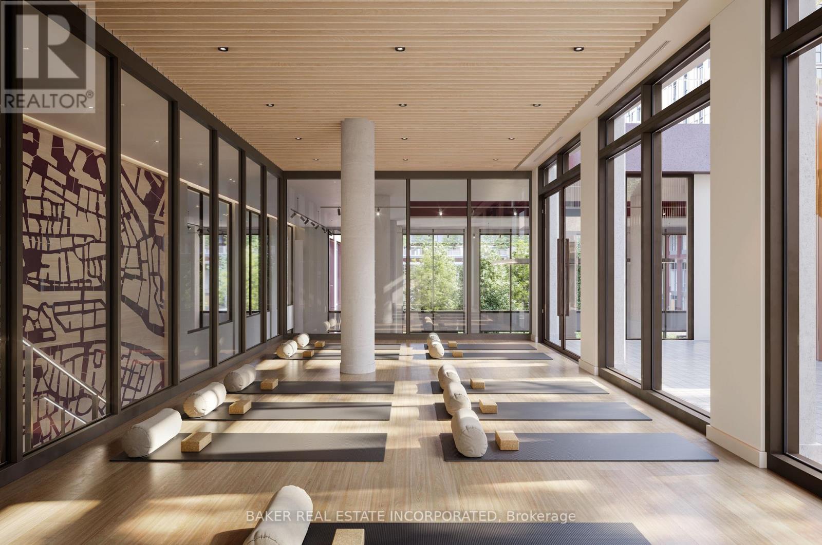 A spacious room with yoga mats and a pillar in the middle.