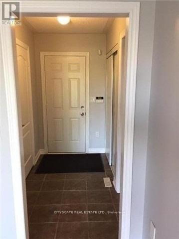 A hallway with a door and a mat on the floor.
