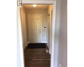 A hallway with a door and a mat on the floor.