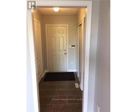 A hallway with a door and a mat on the floor.