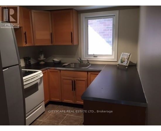A kitchen with wooden cabinets and a black countertop.