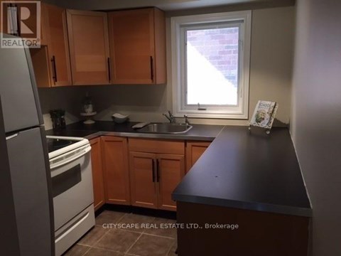 A kitchen with wooden cabinets and a black countertop.