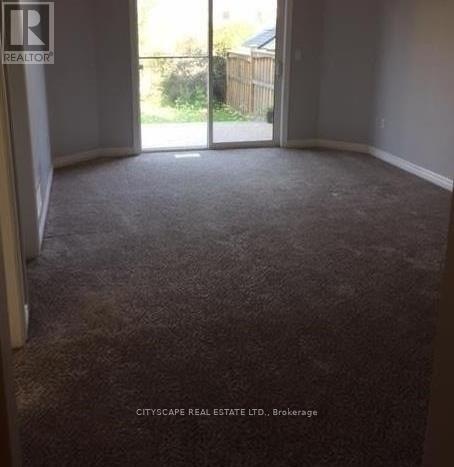 A carpeted room with a sliding glass door leading outside.