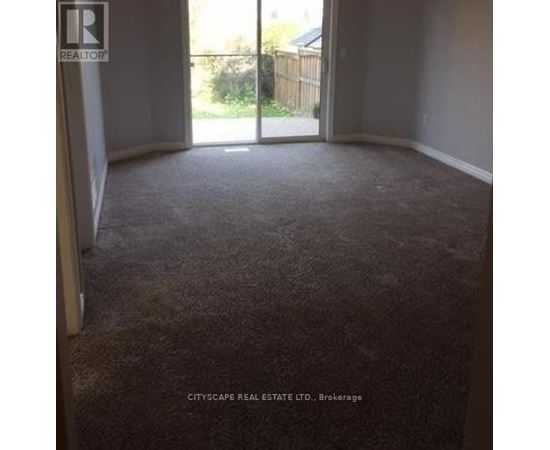 A carpeted room with a sliding glass door leading outside.