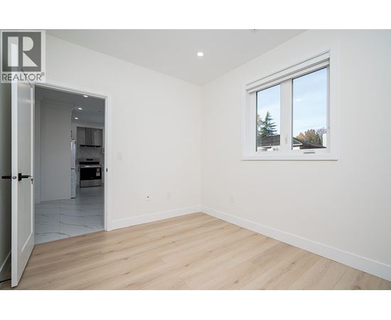 A room with a window showing trees outside.