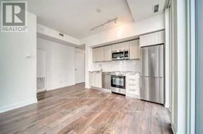 A kitchen with a microwave and oven built into the cabinetry.