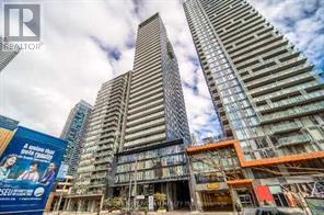 A tall building with a glass facade stands in front of a construction site.