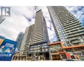 A tall building with a glass facade stands in front of a construction site.