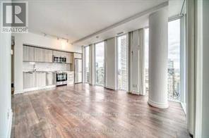 A spacious room with wooden floors and white walls.