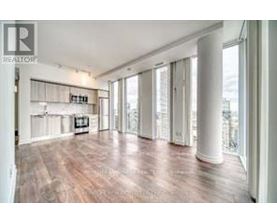 A spacious room with wooden floors and white walls.