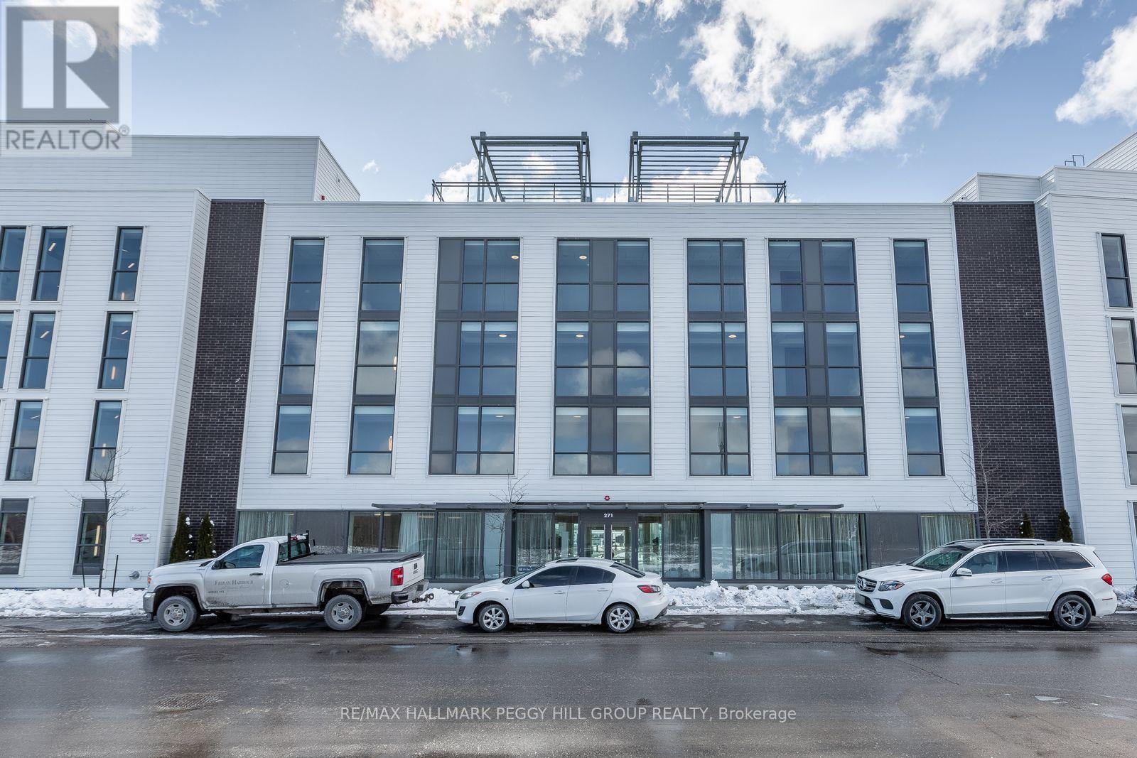 A white building with the RE/MAX Hallmark Peggy Hill Group Realty logo on it.