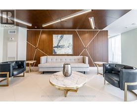 A modern living room with a white sofa, black leather chairs, and a marble coffee table.