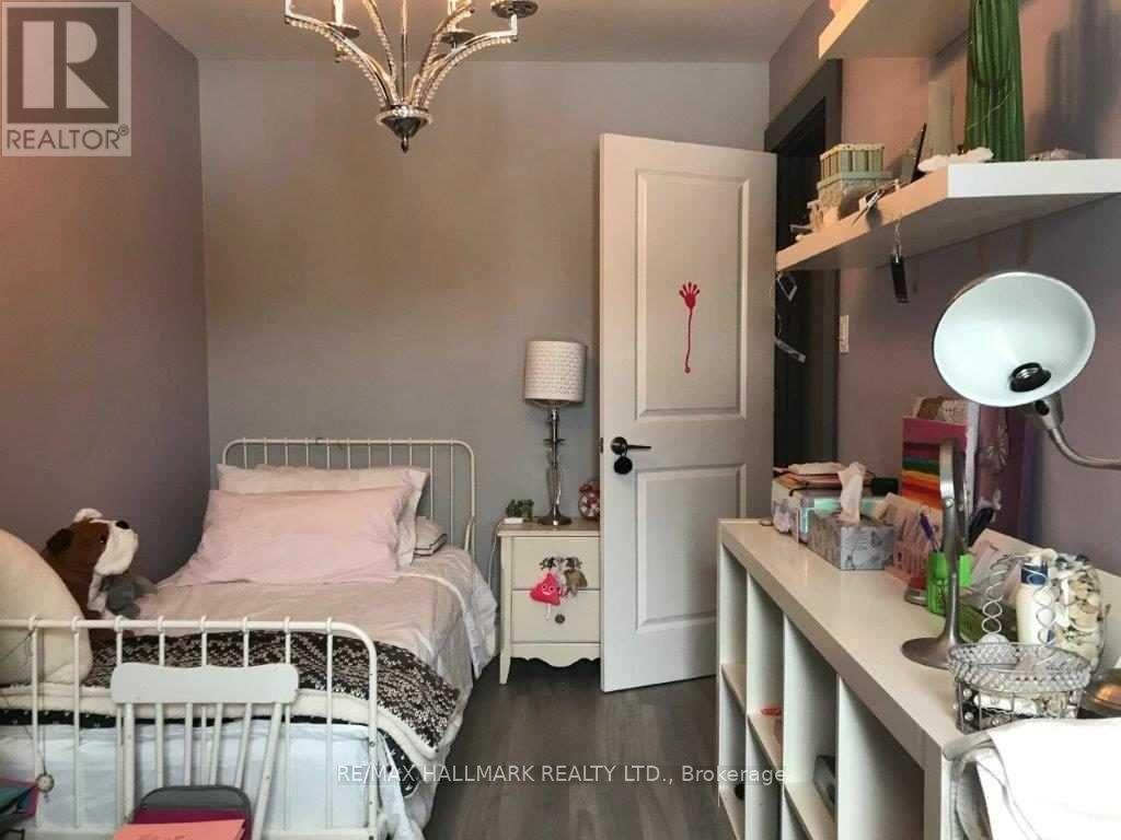 A bedroom with a white bed and a white nightstand with a lamp and a plant on it.