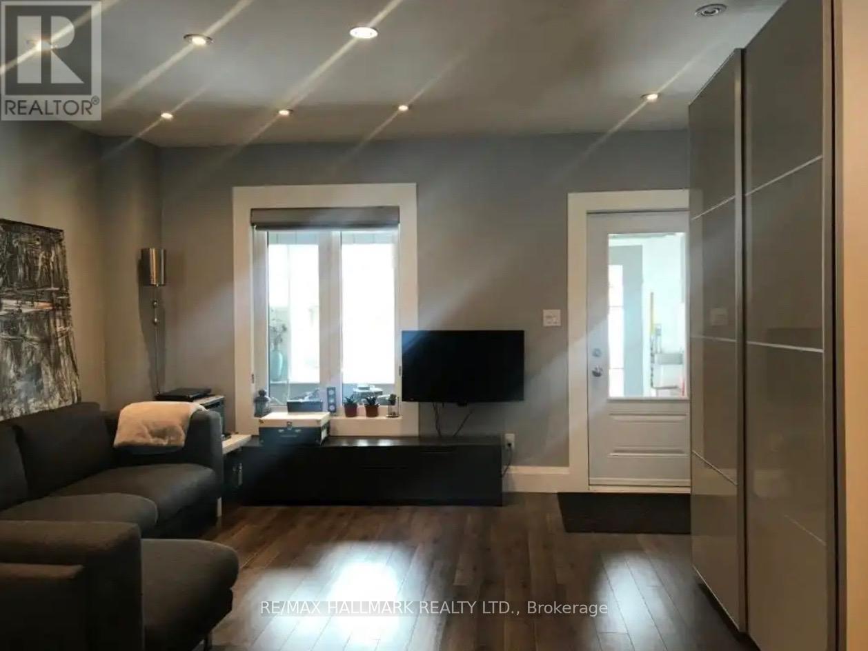 A modern living room with a flat screen TV and a black sofa.