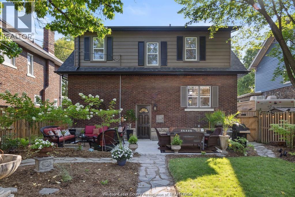 A house with a brick exterior and a patio with a table and chairs.