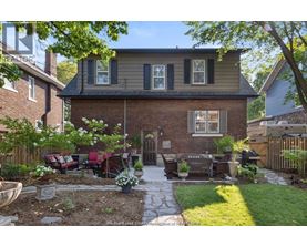 A house with a brick exterior and a patio with a table and chairs.