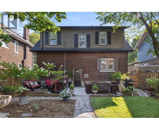 A house with a brick exterior and a patio with a table and chairs.