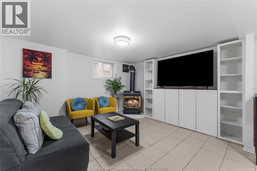 A living room with a grey couch, yellow chairs, a black coffee table, and a flat screen TV.