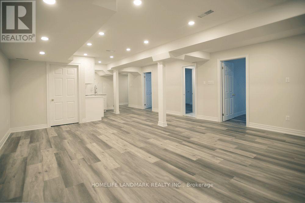 A spacious room with wooden flooring and white walls.