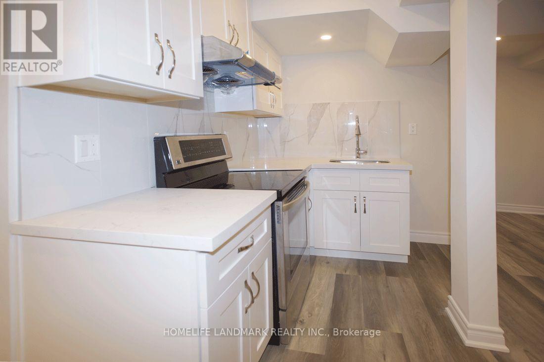 A kitchen with white cabinets and a white countertop.