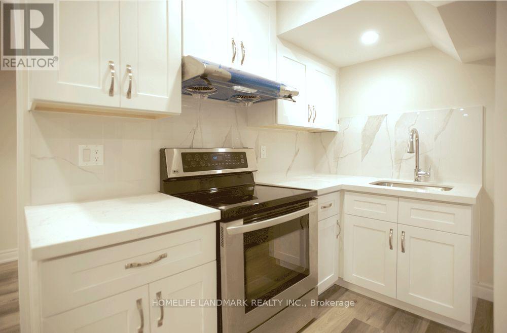 A white kitchen with a black stove top oven.