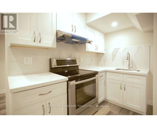 A white kitchen with a black stove top oven.