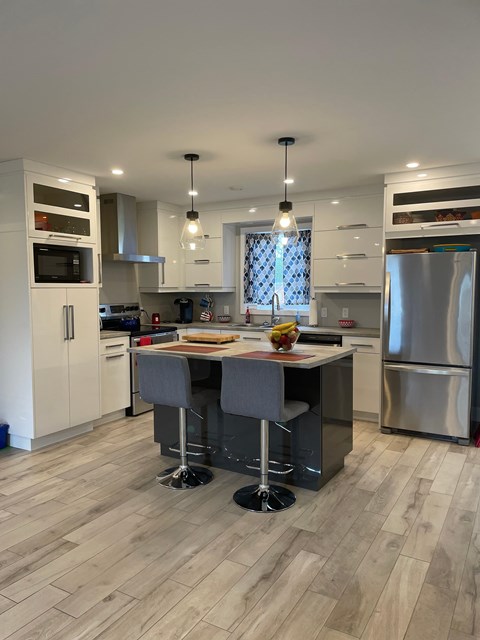 A modern kitchen with a large island and stainless steel appliances.