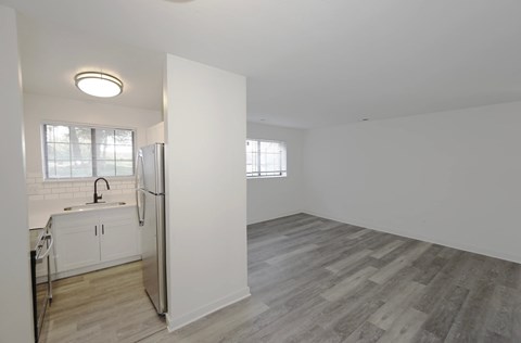 A kitchen with white cabinets and a refrigerator.