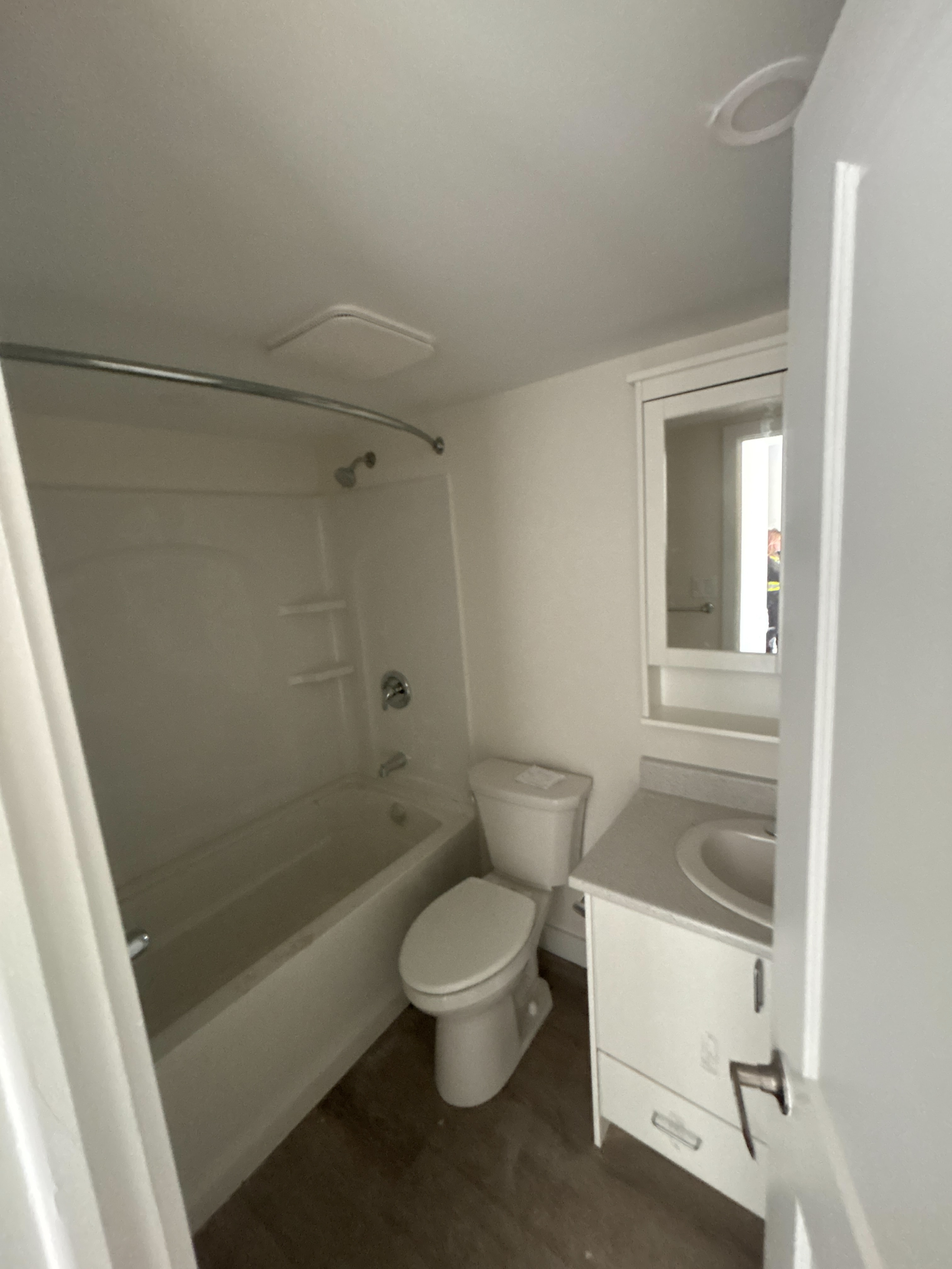 A white bathroom with a toilet, sink, and bathtub.