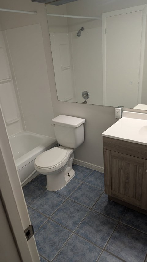 A white toilet in a bathroom with a white shower curtain.