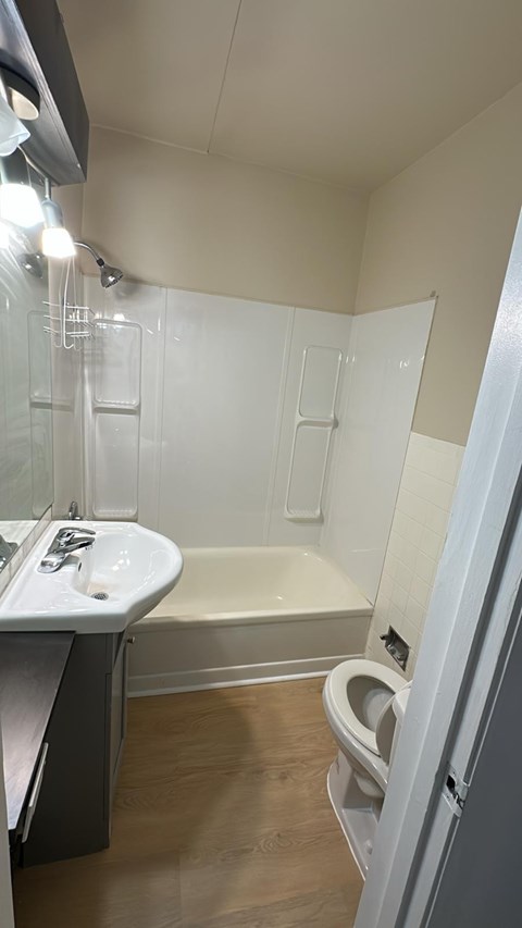 A white sink with a white toilet and a white bathtub in a bathroom.