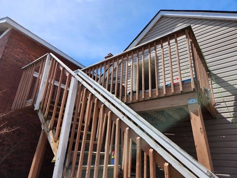 A wooden staircase is being built between two houses.