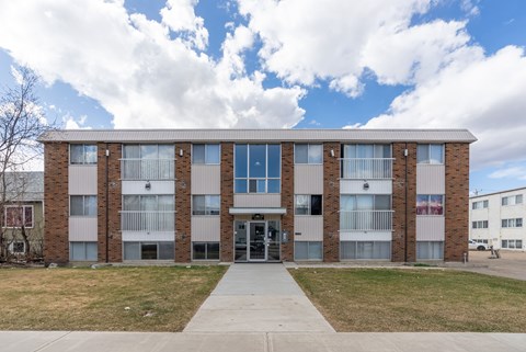 A large building with a grassy area in front.