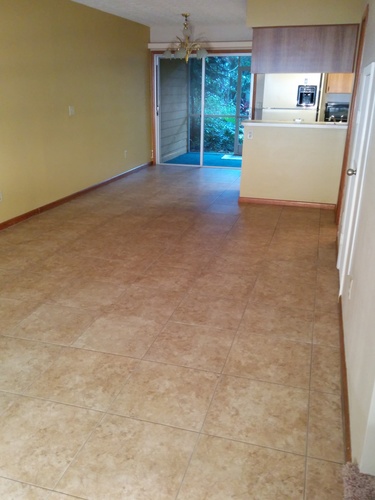 A room with a yellow wall and tile flooring.