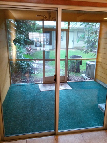 A glass door with a view of a backyard.