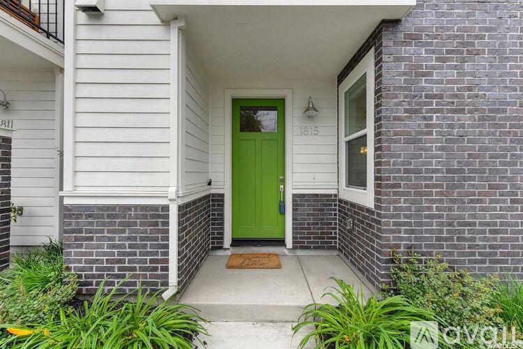 A house with a green door and a white siding.