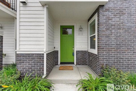 A house with a green door and a white siding.