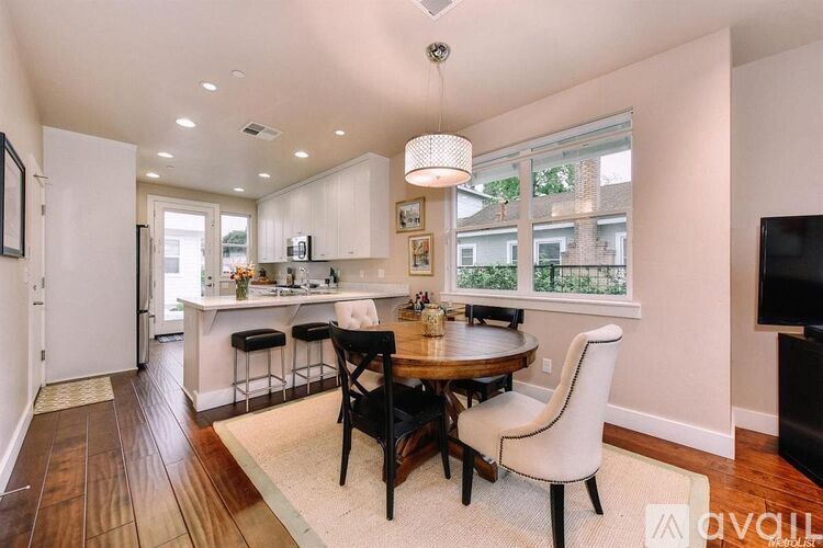 A well-lit kitchen with a dining table and chairs.