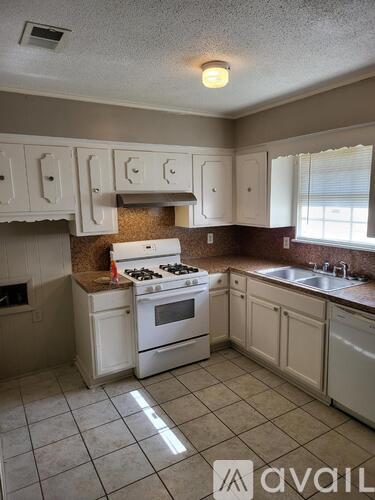 A kitchen with white appliances and cabinets.