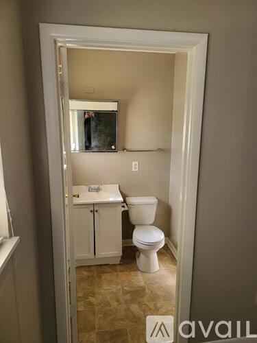 A bathroom with a toilet, sink and medicine cabinet.
