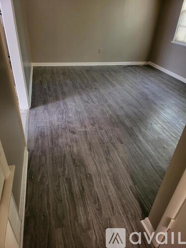 A room with wooden flooring and a window.