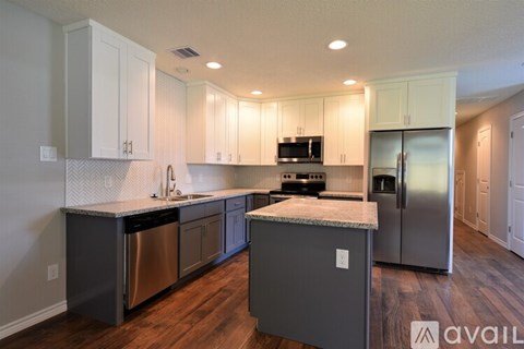 A kitchen with a white counter top and stainless steel appliances.