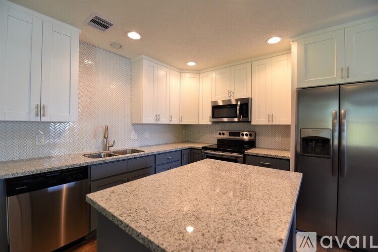 A kitchen with granite countertops and stainless steel appliances.