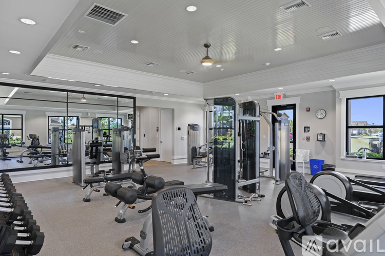 A spacious gym with a variety of equipment and a view of the outdoors.
