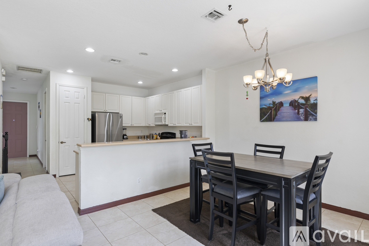 A kitchen with a dining table and chairs.