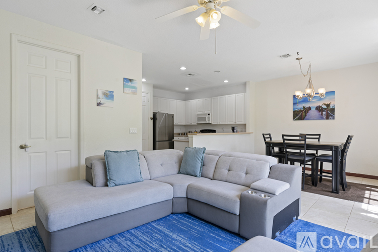 A living room with a grey couch and a blue rug.