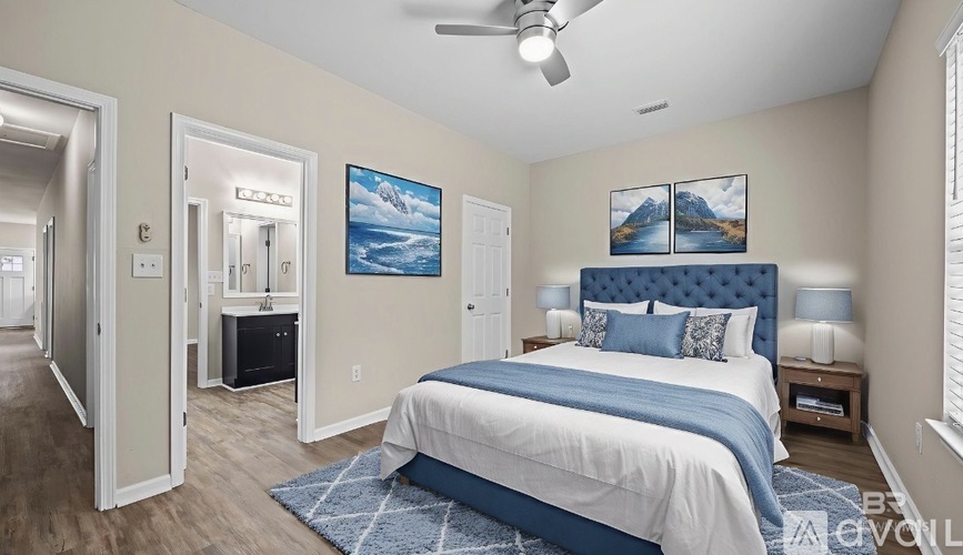 A bedroom with a bed, a ceiling fan, and a painting of a mountain landscape.